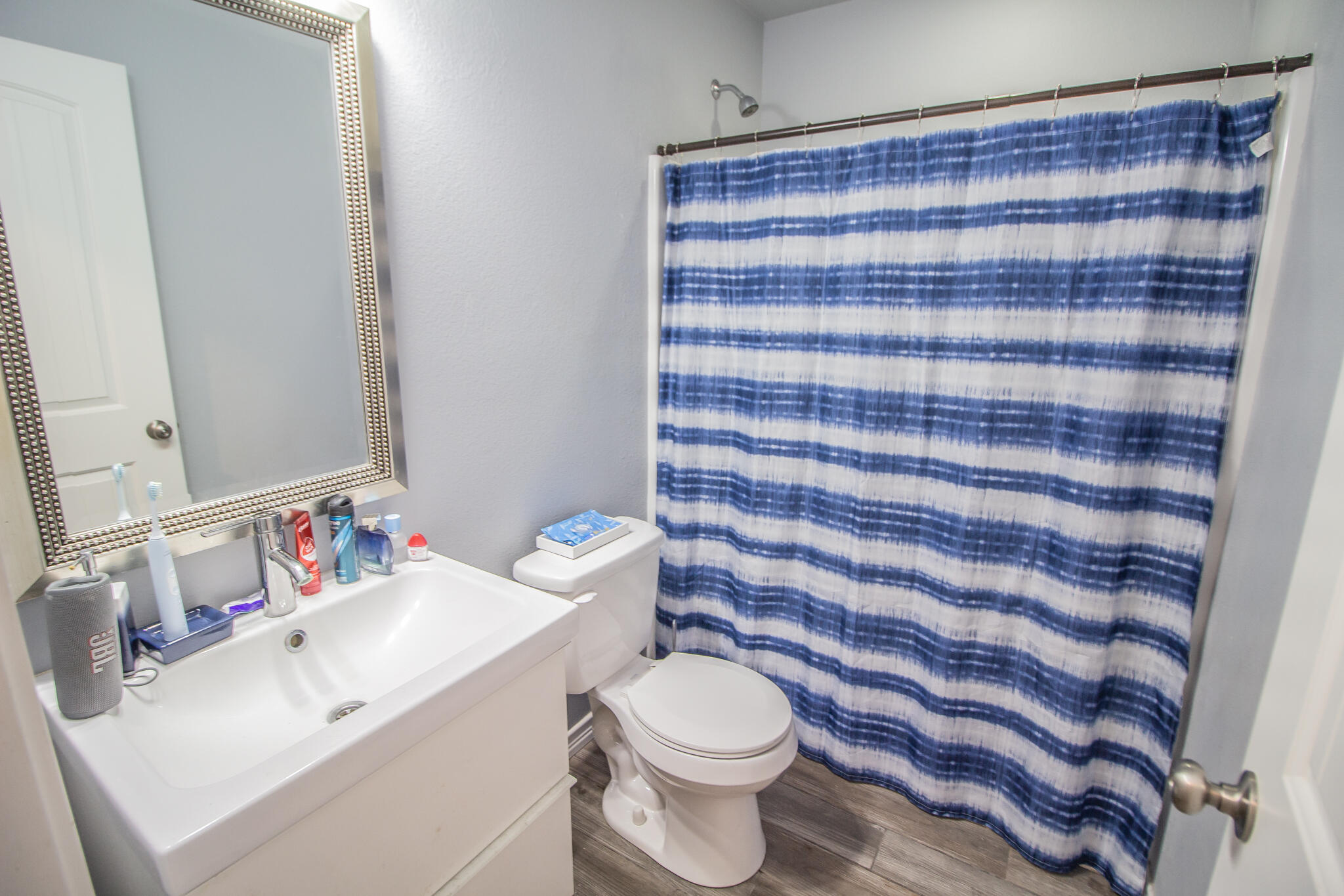 8808 14th Street Lubbock, TX 79416 - Photo 15 of 19 a bathroom with a sink a toilet and a mirror
