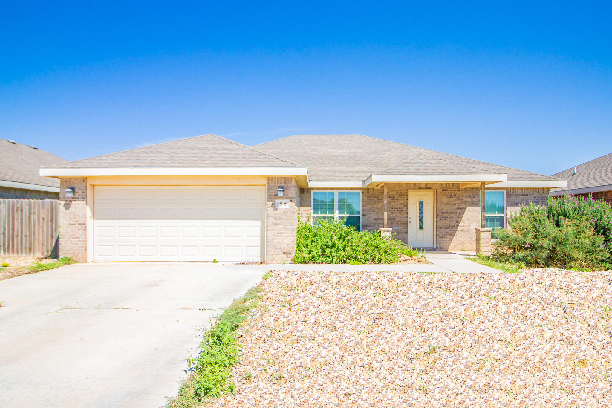 8808 14th Street Lubbock, TX 79416 - Photo 2 of 19 a front view of a house with a yard and garage