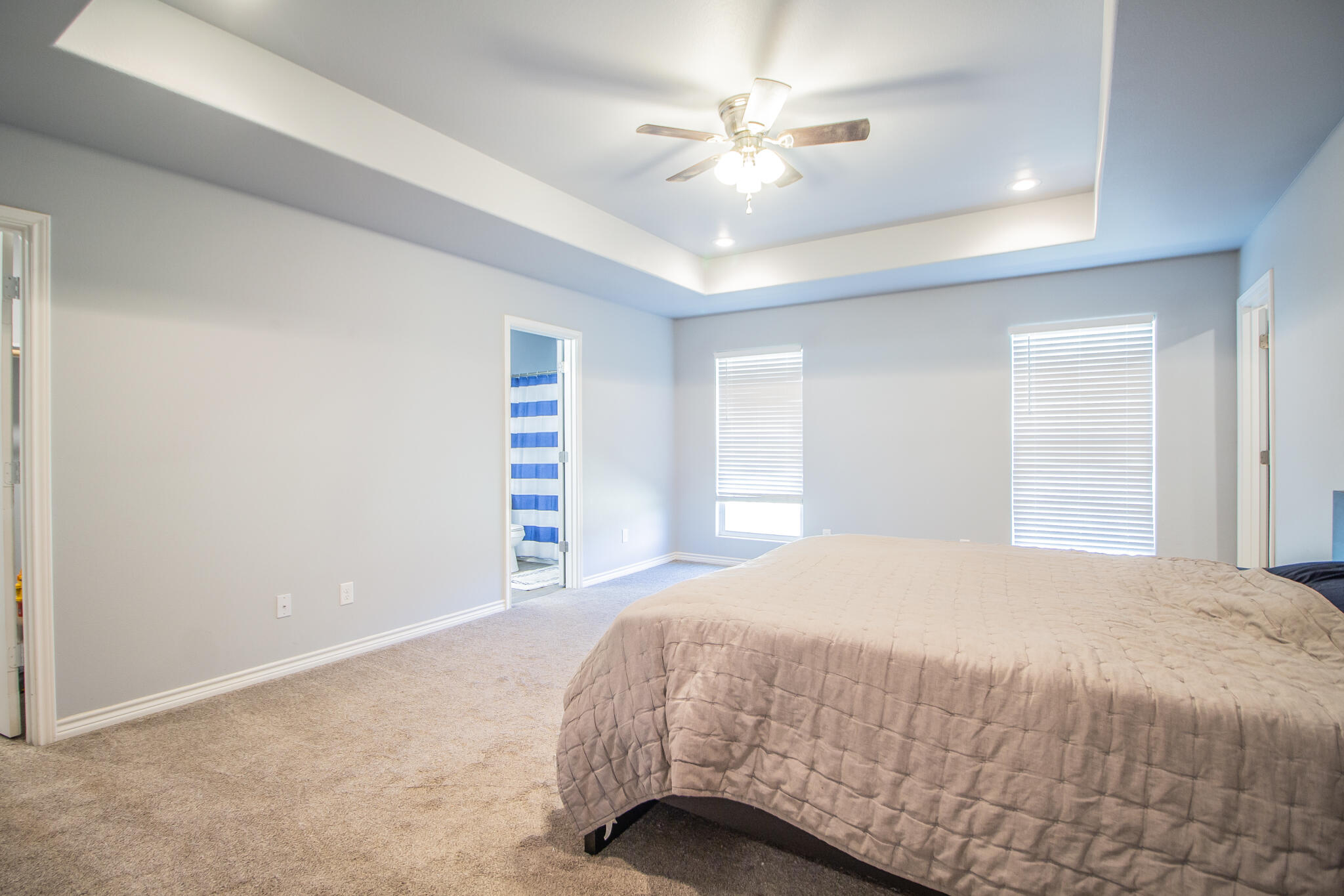 8808 14th Street Lubbock, TX 79416 - Photo 10 of 19 a bedroom with a bed and a chandelier