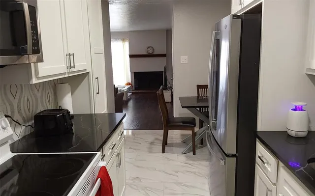 a kitchen with a sink a refrigerator and cabinets