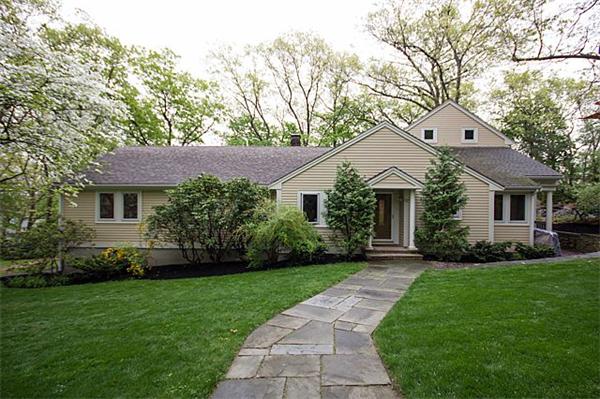 a front view of a house with a garden and plants