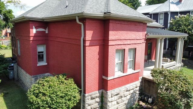 a red brick house with large windows and a yard