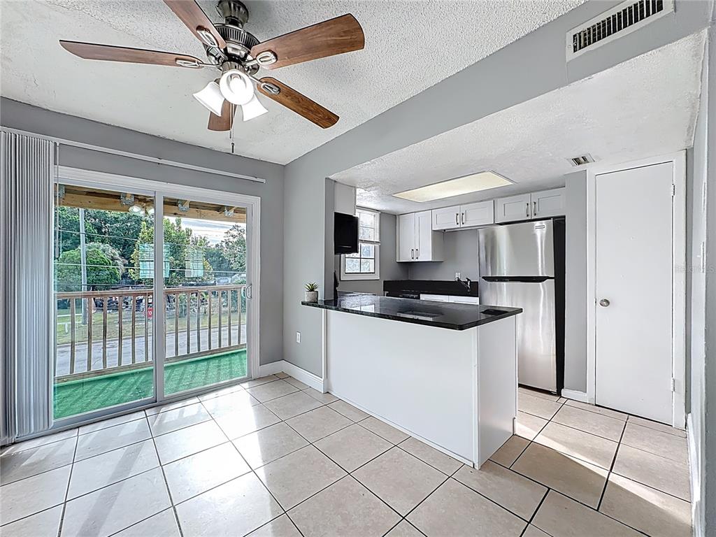 2753 L B McLeod Road, Unit D Orlando, FL 32805 - Photo 11 of 48 a kitchen with stainless steel appliances granite countertop a refrigerator a sink a stove top oven and a large window