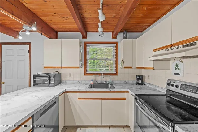 a kitchen with stainless steel appliances granite countertop a sink a stove and cabinets