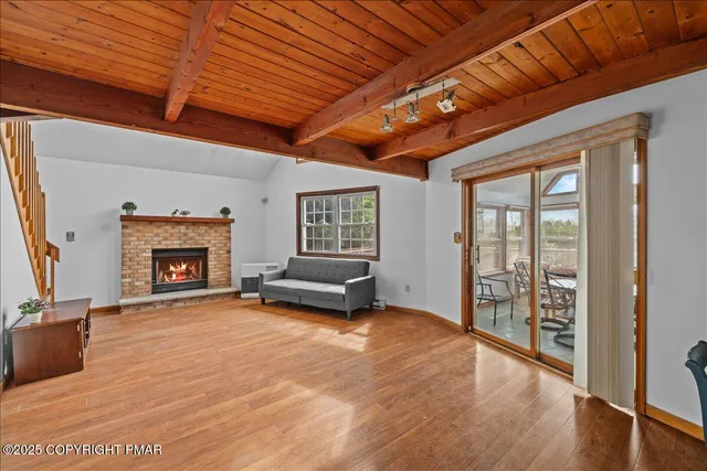 a view of an empty room with a fireplace and a window