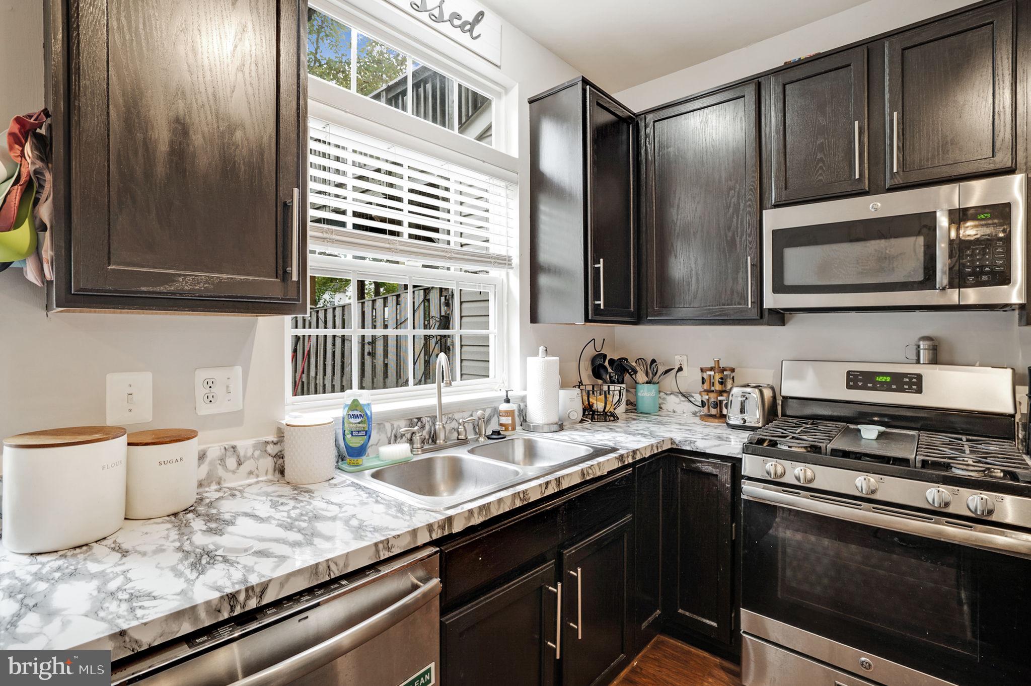 9835 Maitland Loop Bristow, VA 20136 - Photo 11 of 41 a kitchen with stainless steel appliances granite countertop a sink stove and microwave
