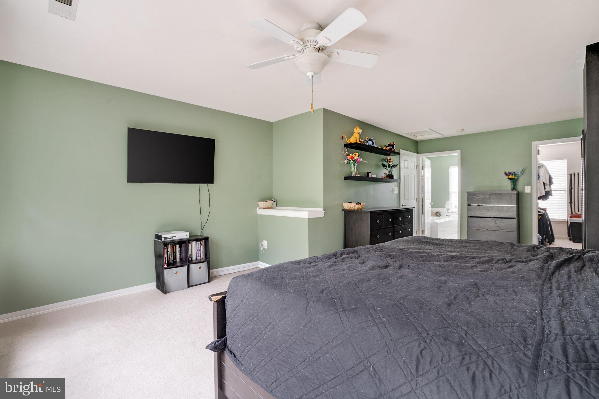 9835 Maitland Loop Bristow, VA 20136 - Photo 18 of 41 a bedroom with a bed and a flat screen tv