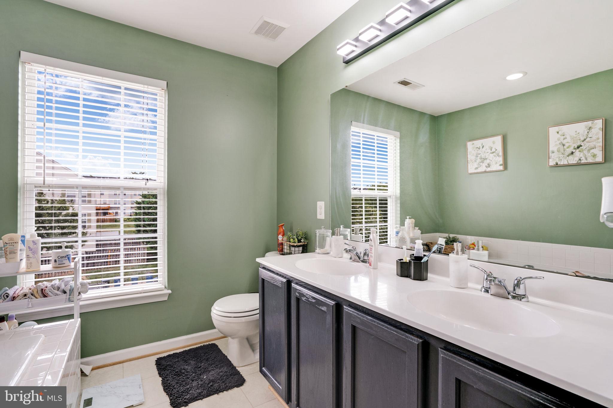 9835 Maitland Loop Bristow, VA 20136 - Photo 22 of 41 a bathroom with a double vanity sink toilet and a window