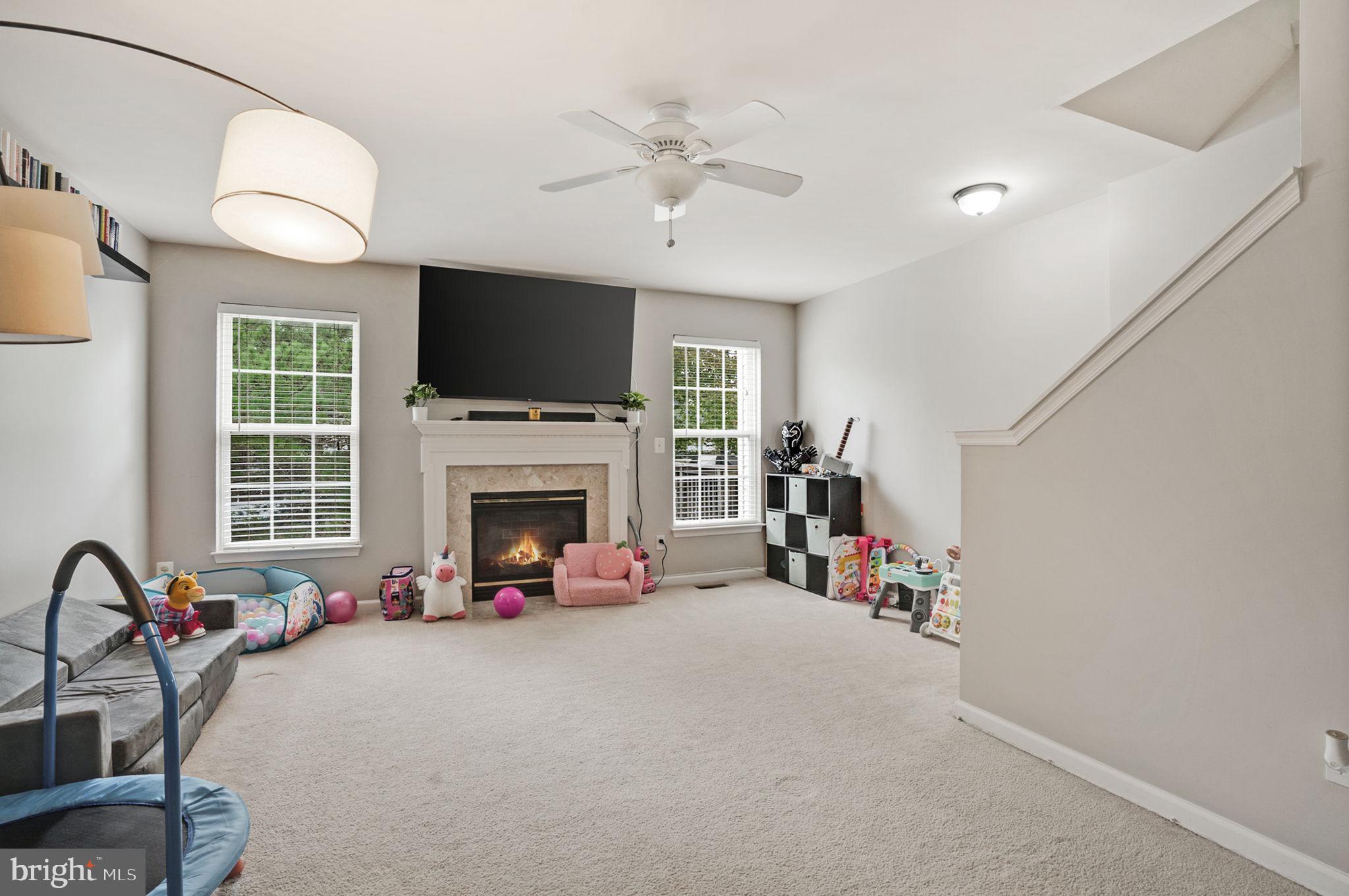 9835 Maitland Loop Bristow, VA 20136 - Photo 32 of 41 a view of a livingroom with furniture a fireplace a flat screen tv and a window