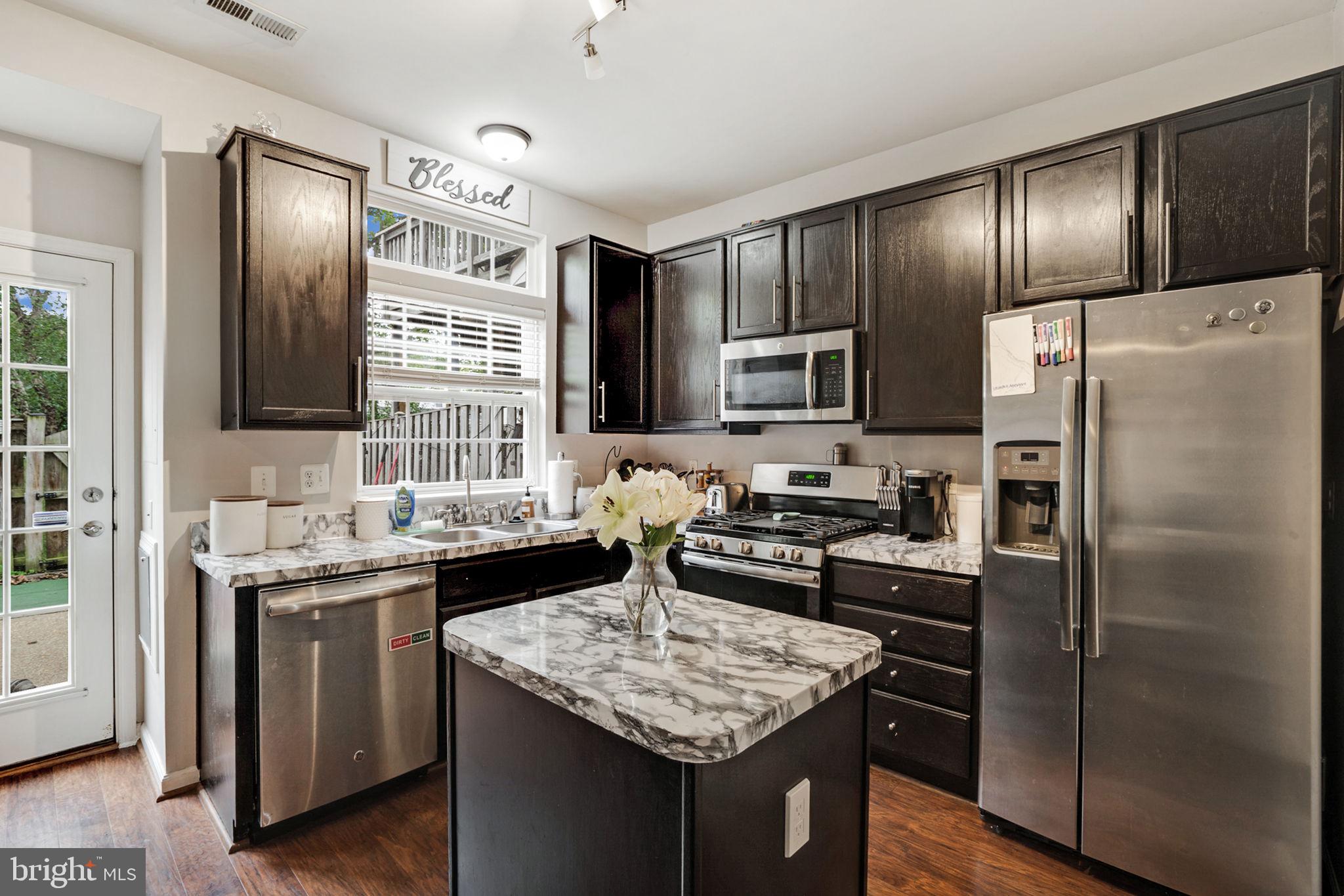 9835 Maitland Loop Bristow, VA 20136 - Photo 9 of 41 a kitchen with granite countertop stainless steel appliances and wooden cabinets