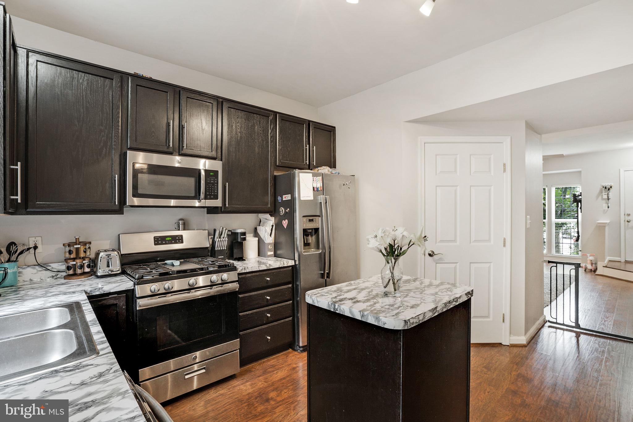 9835 Maitland Loop Bristow, VA 20136 - Photo 10 of 41 a kitchen with granite countertop stainless steel appliances and wooden cabinets