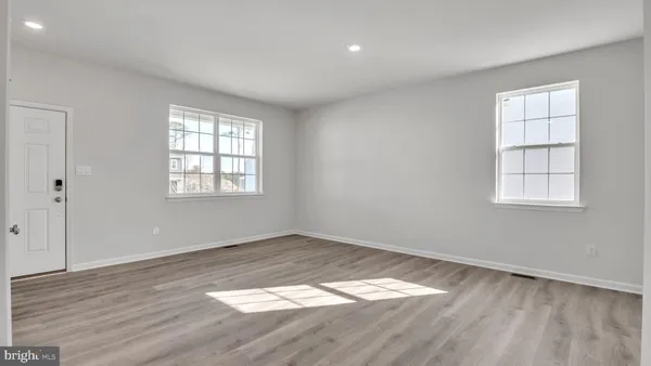 a view of kitchen with kitchen island a sink wooden floor and a refrigerator