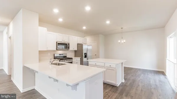 a kitchen with a sink a stove a refrigerator and a microwave