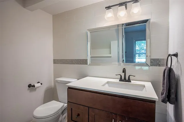a bathroom with a sink toilet and mirror