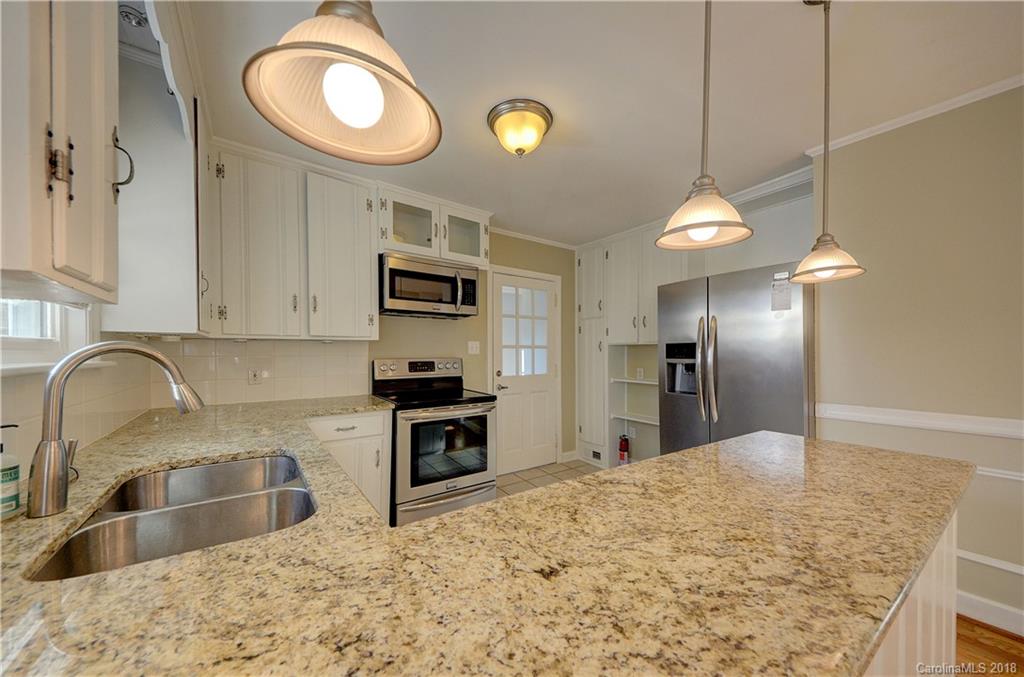 4301 Applegate Road Charlotte, NC 28209 - Photo 11 of 30 a kitchen with stainless steel appliances kitchen island granite countertop a sink a stove and a refrigerator