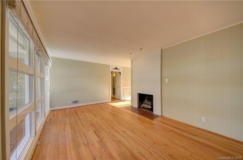 4301 Applegate Road Charlotte, NC 28209 - Photo 4 of 30 a view of empty room with wooden floor and fireplace