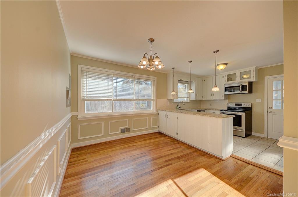 4301 Applegate Road Charlotte, NC 28209 - Photo 8 of 30 a kitchen with granite countertop a refrigerator and white cabinets