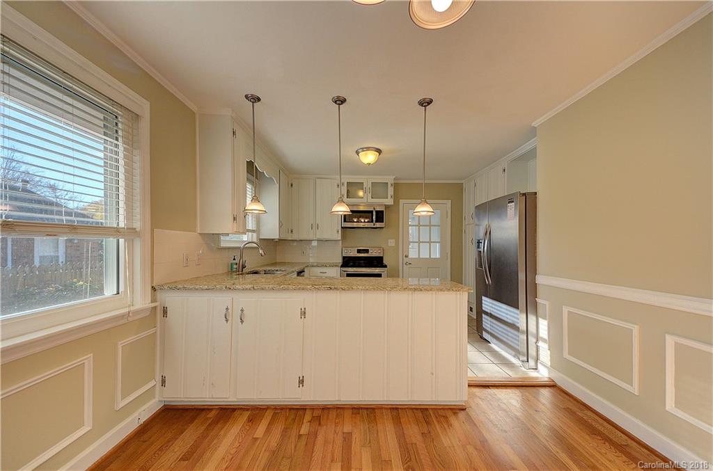 4301 Applegate Road Charlotte, NC 28209 - Photo 10 of 30 a large kitchen with stainless steel appliances a large counter top a stove and a wooden floors