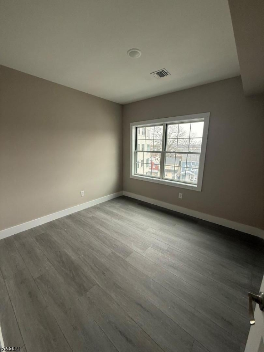 1022 Main Street, Unit 404 Paterson, NJ 07503 - Photo 5 of 7 an empty room with wooden floor and windows