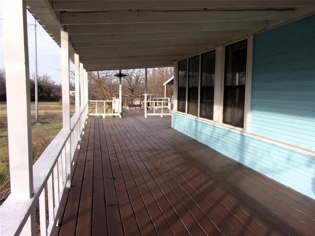 a view of a balcony with wooden floor and fence