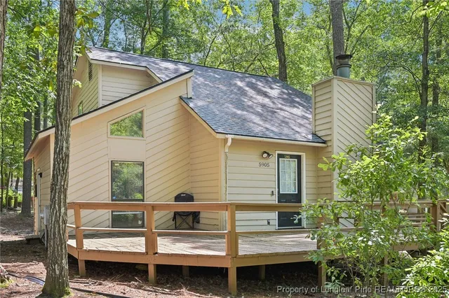 a view of house with a large window and wooden fence
