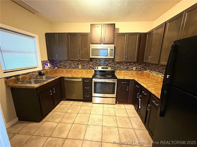 a kitchen with a sink stove top oven and cabinets