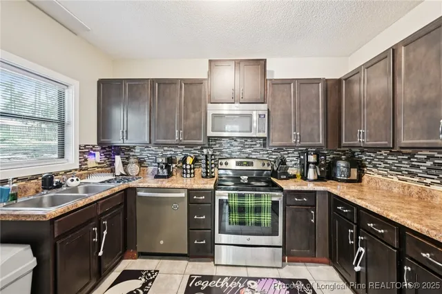 a kitchen with stainless steel appliances a stove sink and cabinets