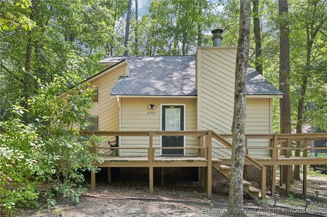 a view of house with a backyard and a tree