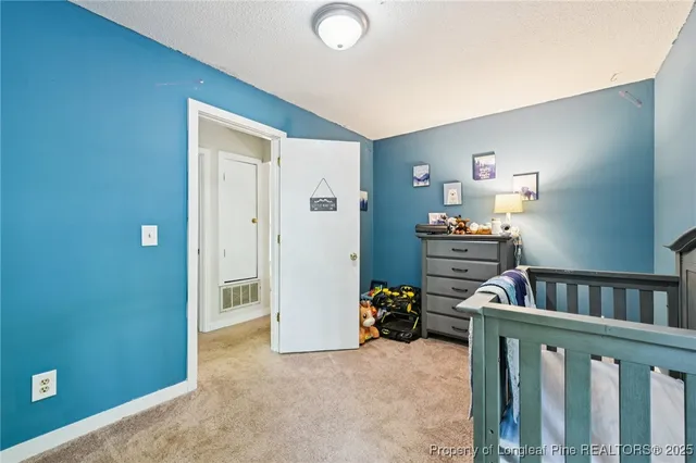 a spacious bedroom with a bed and a dresser