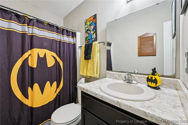 a bedroom with a bed and dresser with mirror