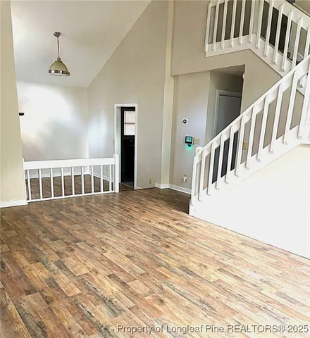 a view of a bedroom with wooden floor and stairs