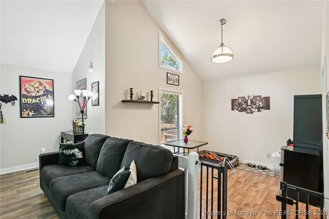 a living room with furniture a flat screen tv and a wall painting