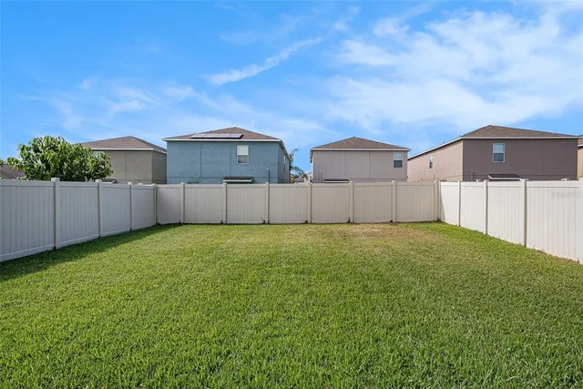 a view of a backyard with wooden fence