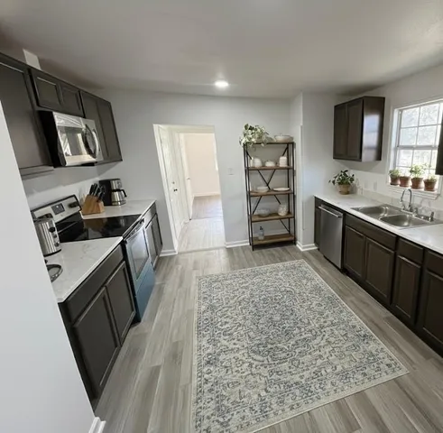 a kitchen with sink refrigerator and stove