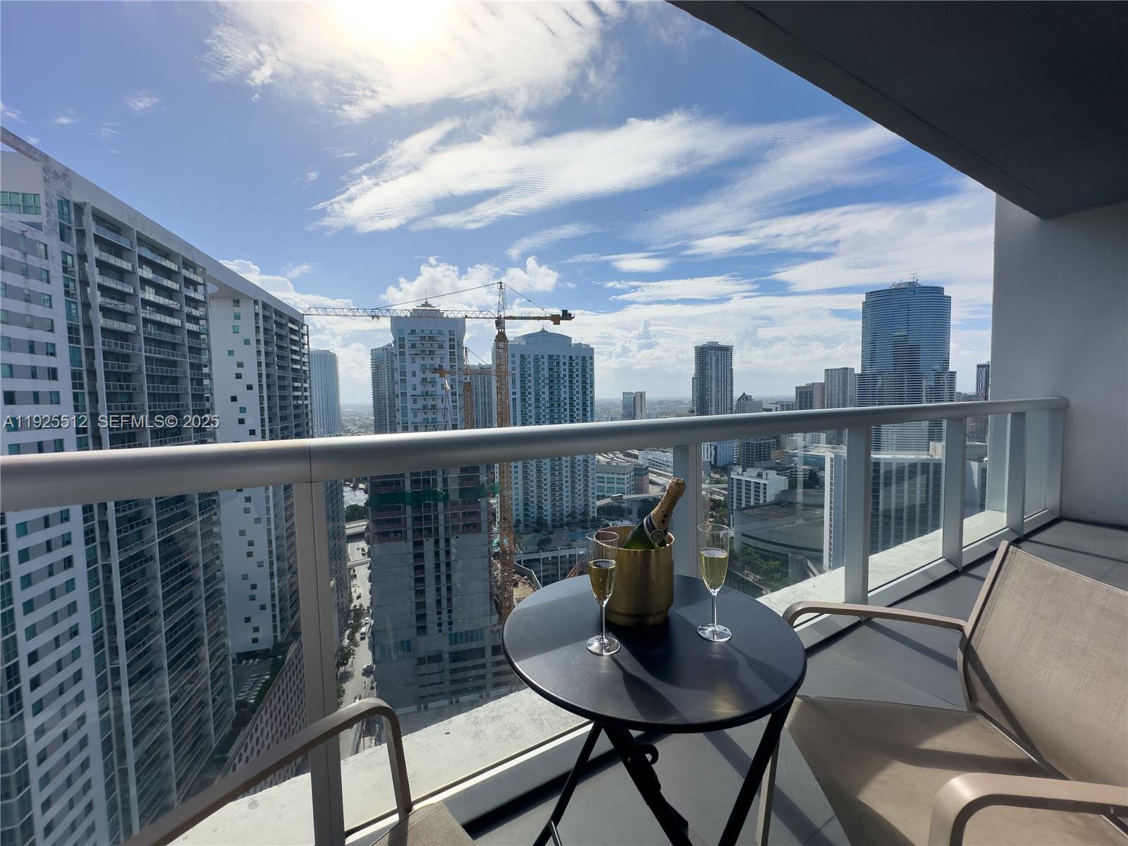 485 Brickell Avenue, Unit 3307 Miami, FL 33131 - Photo 2 of 17 a view of a balcony with wooden floor and outdoor seating