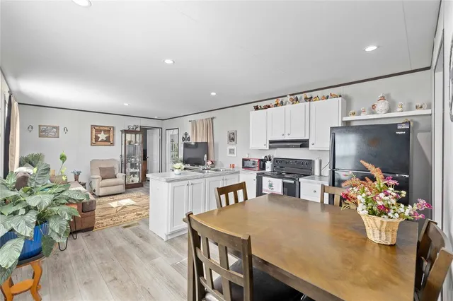 a living room with stainless steel appliances furniture a dining table and chairs