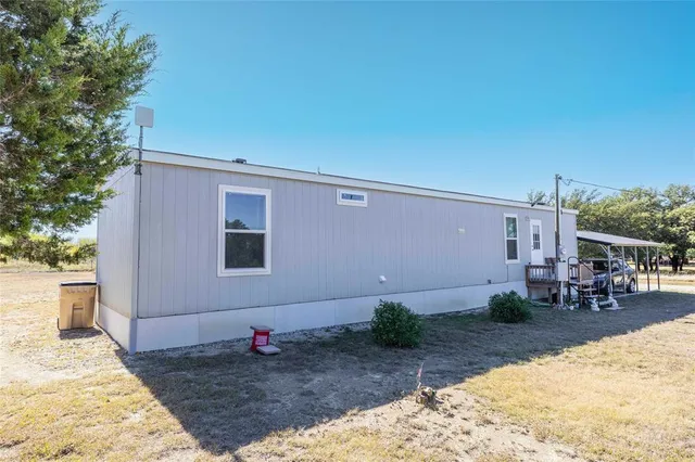 a backyard of a house with table and chairs