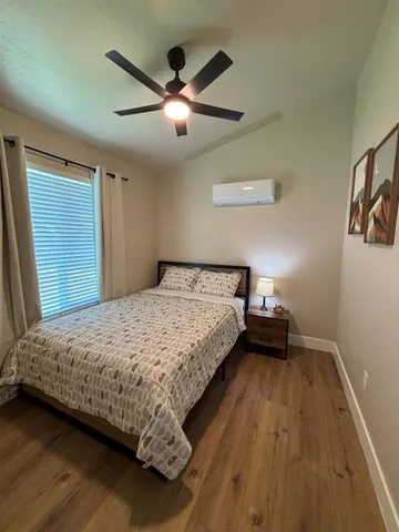 a bedroom with a bed and a ceiling fan
