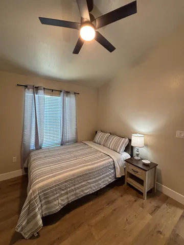 a bedroom with a bed and a ceiling fan