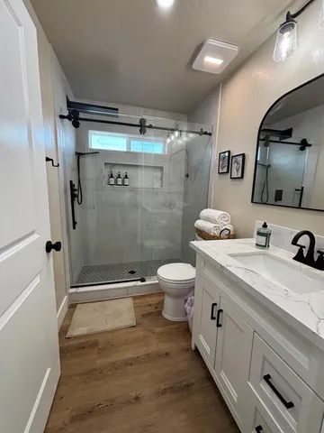 a bathroom with a sink a toilet and shower