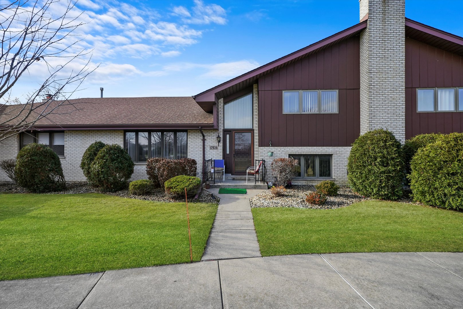 a front view of a house with garden and porch