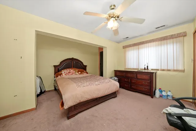 a spacious bedroom with a bed and a flat screen tv