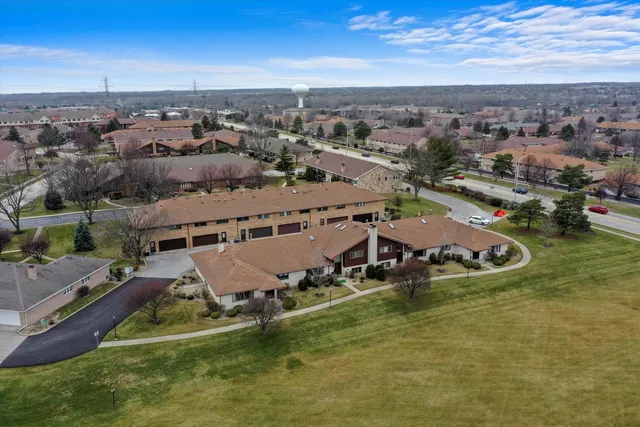 an aerial view of a house with a garden and lake view