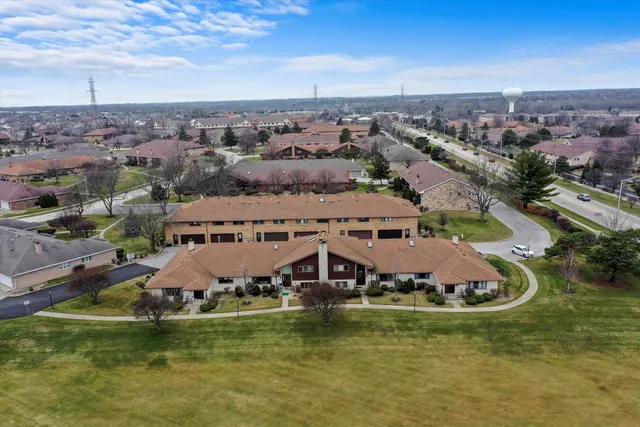an aerial view of a house with a garden and lake view