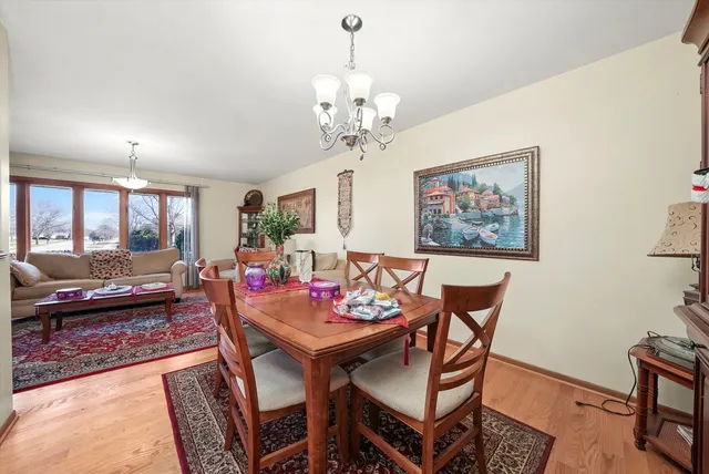 a view of a dining room with furniture a rug and wooden floor