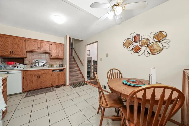 a kitchen with granite countertop a dining table chairs and white cabinets