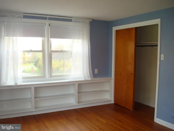 an empty room with wooden floor and closet