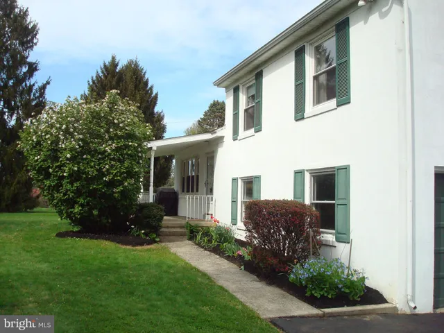 a front view of a house with a yard and trees
