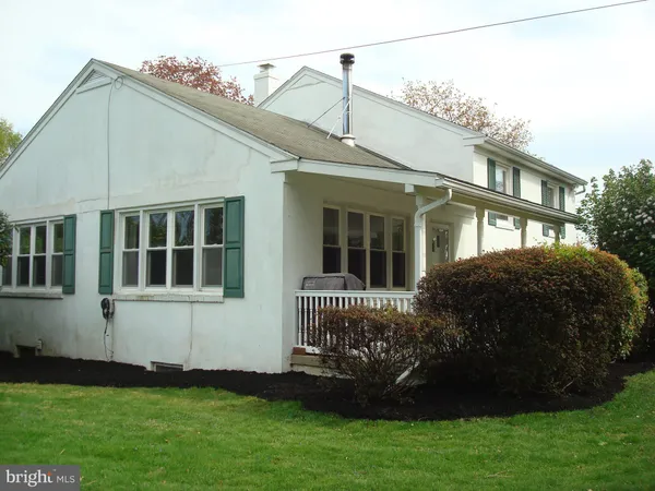 a view of a white house with a yard