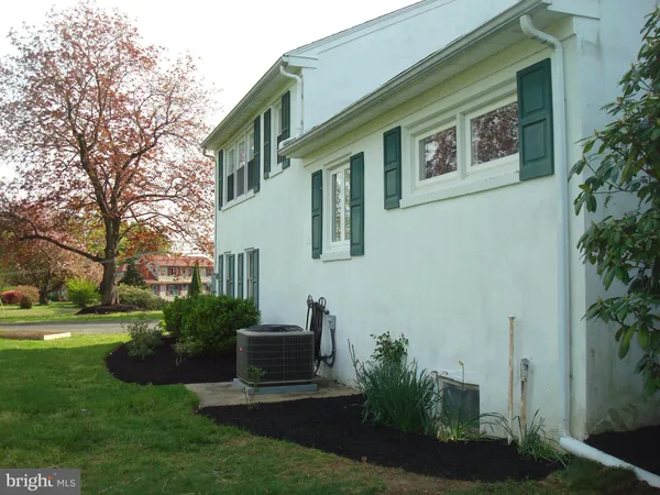 a view of a house with a big yard potted plants and large tree